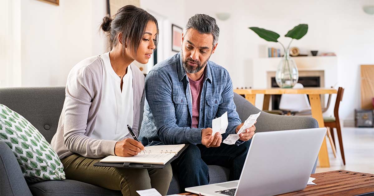 Two people looking at receipts and talking about costs.