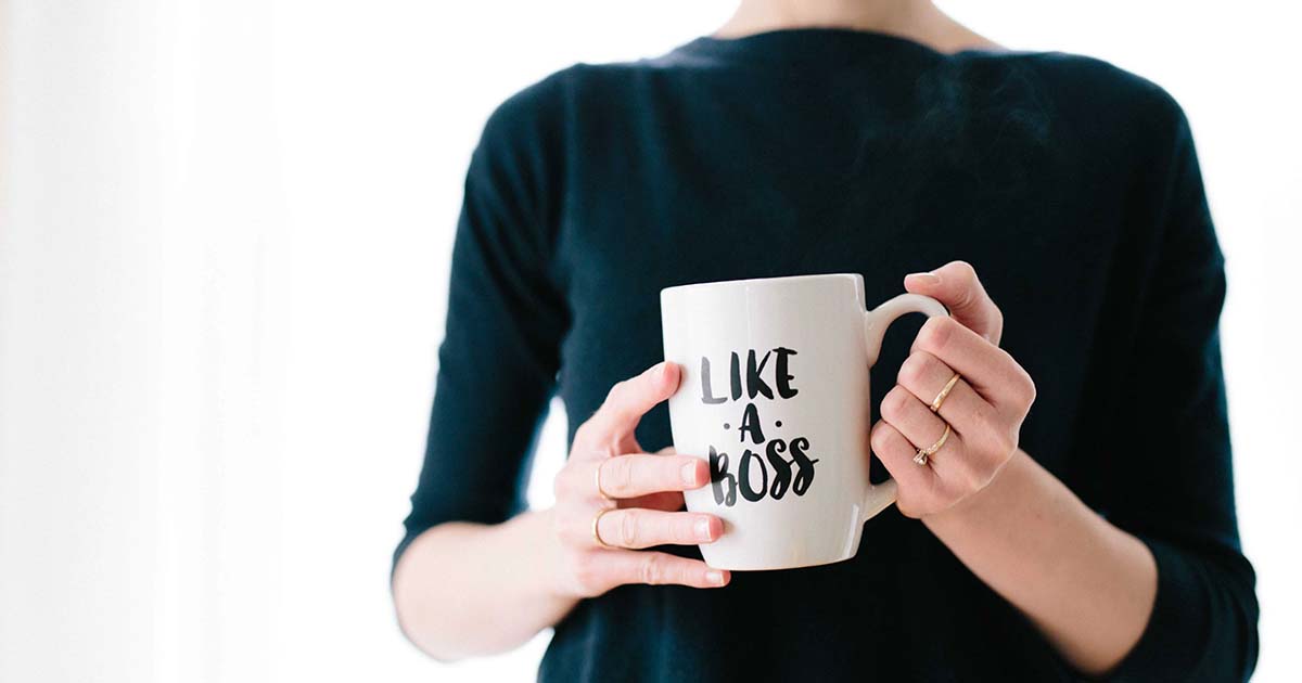Woman holding a mug stating, Like a Boss.