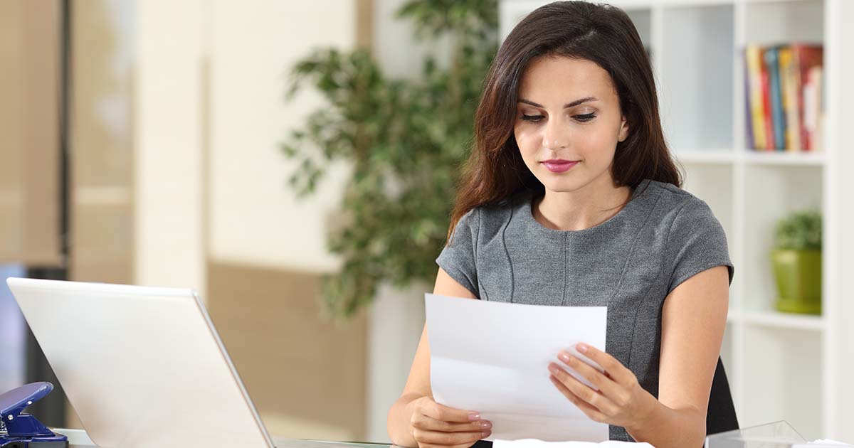 Woman sitting in her office reading a document.